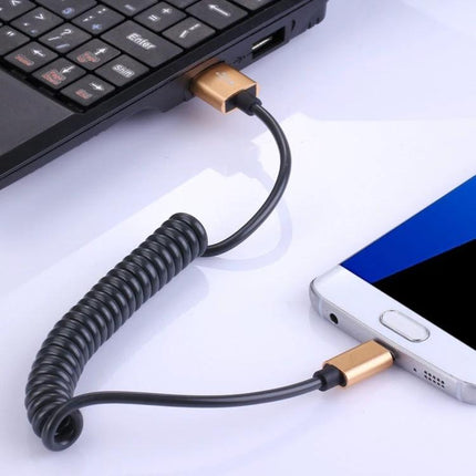 Micro USB Cable for Charging and Data Transfer in Daily Life coiled cable connecting smartphone to laptop for reliable charging and data sync