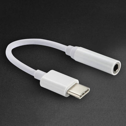 Compact Adapter for Connecting Headphones to USB-C Devices — white USB-C to 3.5mm headphone adapter on dark background