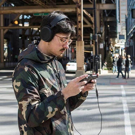 Sound Card Connecting Cable for SteelSeries Arctis Headphones — gamer using Arctis headphones with 1.5m cable connecting to phone on city street