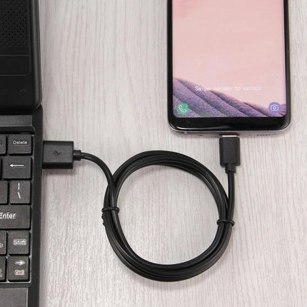 Cable for Charging Devices in Daily Home and Travel Use: Type-C cable connected between laptop and smartphone for reliable everyday charging