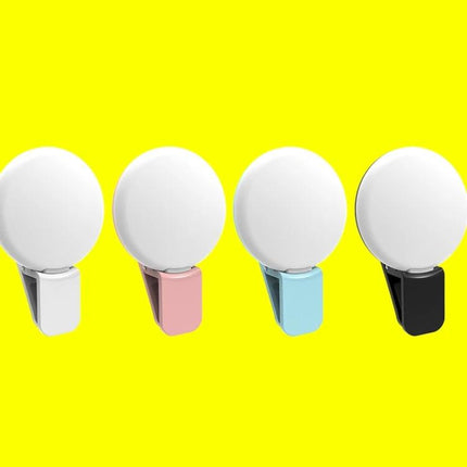 Compact Phone Light for Daily Video Calls and Social Media showing four clip-on portable phone lights in white, pink, blue, and black on yellow background
