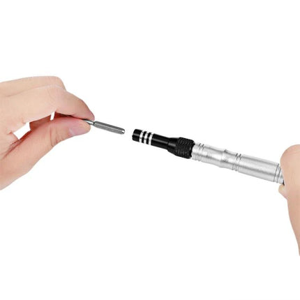Jakemy 34-in-1 Multipurpose Screwdriver Set for DIY Repairs showing hand inserting precision bit into metal driver for electronics and craft work