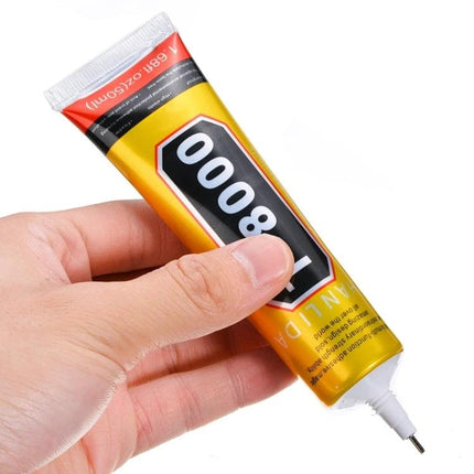 Hand holding a gold tube labeled 8000 — 50ml T-8000 Multi-Function Adhesive for Crafts and Repairs for jewelry, fabric and ceramic mending