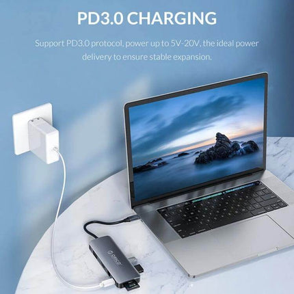 Orico 11-in-1 Multifunction Docking Station for Device Connectivity connected to laptop showing PD3.0 charging and multiple ports