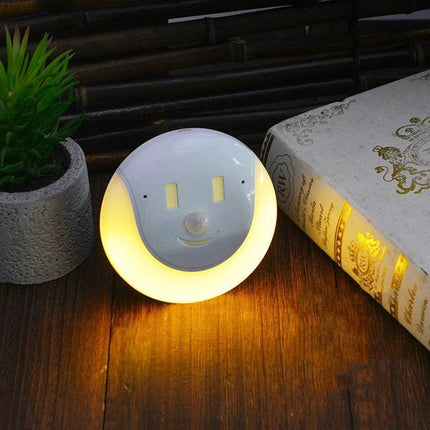 Night Light for Home Safety in Dark Hallways at Night - motion sensor LED nightlight on wooden floor beside book