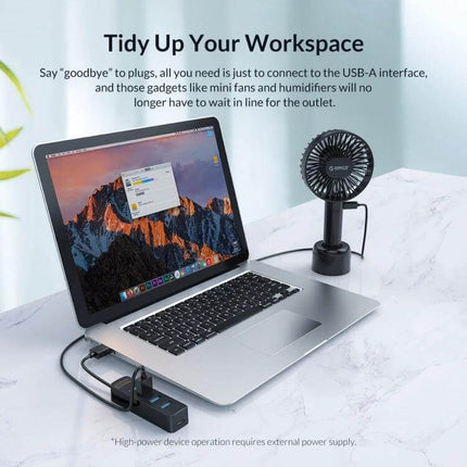 Orico Black 7-Port USB Hub for Connecting Multiple Devices Daily on a laptop desk setup with fan and external drives