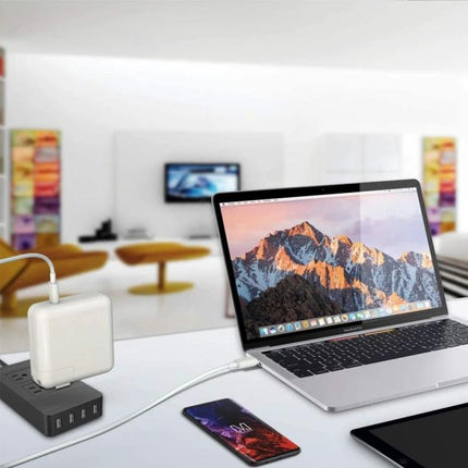 Travel Essential for Charging Devices on the Go Worldwide - USB-C travel charger powering laptop and phone in modern hotel workspace