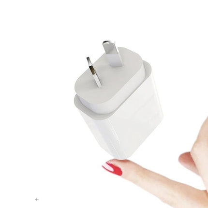 Compact AU Plug Charger for Everyday Travel Essentials shown small white charger held near fingertip for pocketable on-the-go charging