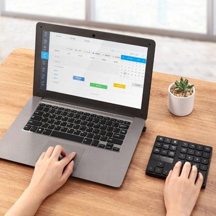 Wireless Numeric Keypad for Efficient Laptop Data Entry - compact 35-key wireless numeric keypad in use beside laptop for fast spreadsheet and accounting input