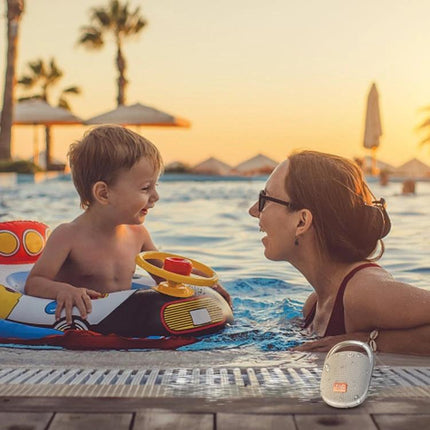TG Portable Bluetooth Speaker With Sound Reactive Lights by pool at sunset beside mother and child enjoying music