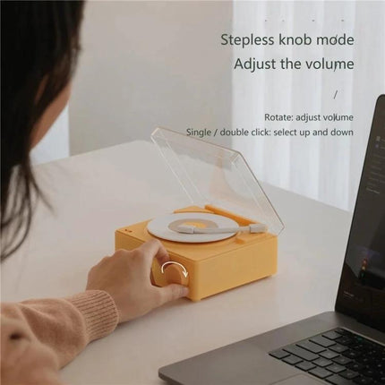 Duosi Retro Bluetooth Desk Speaker With Hidden Display And Alarm on desk with hand adjusting stepless volume knob