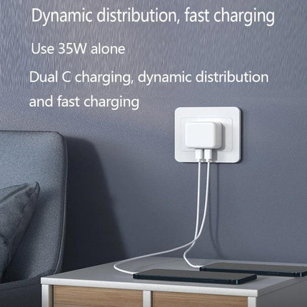 Compact Dual USB-C Charger for Everyday Home and Travel Use plugged into wall charging a phone and tablet with two cables