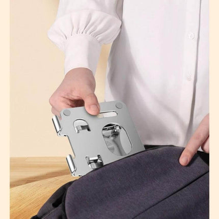 Ergonomic Adjustable Height Laptop Stand with 360 Rotation being placed into a backpack for travel, compact foldable aluminum design