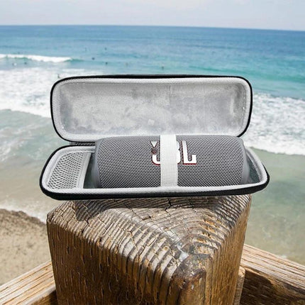 Compact Water Resistant Travel Case For Portable Bluetooth Speakers on a beach pier protecting a JBL Flip speaker