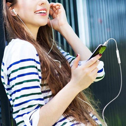 Adapter for Connecting Headphones to Smartphones Daily - woman using USB C to 3.5mm headphone adapter with phone during outdoor walk