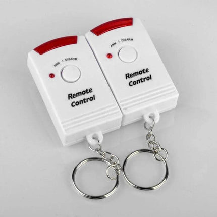 Wireless Infrared Motion Sensor Alarm for Home Security keyfob remote controls paired with white wireless motion sensor alarm units