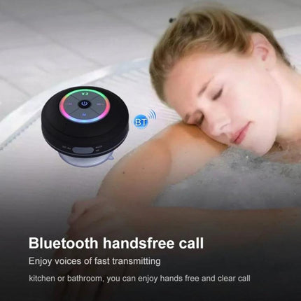Compact Waterproof Shower And Beach Speaker With Suction Cup next to relaxed person in bathtub with LED lights