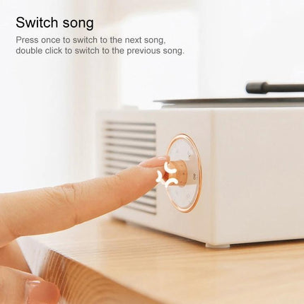 X10 Compact Retro Bluetooth Speaker With Rose Gold Dial shown with finger pressing rose gold dial to switch song