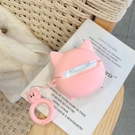 Cute Pig-Shaped Case for Everyday AirPods Protection in pink with dustproof exterior and reserved charging port, shown on a chair with matching pig keyring