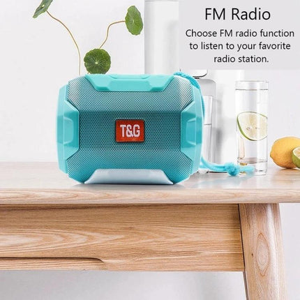 Portable Bluetooth Speaker With FM Radio For Home And Travel shown in turquoise on a table with FM radio text and glass