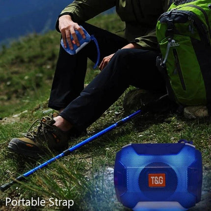 Portable Bluetooth Speaker With FM Radio For Home And Travel compact blue travel speaker with strap beside hiker 100 chars