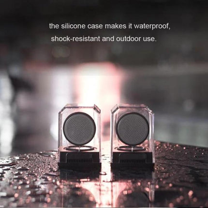 Transparent Portable Bluetooth Speaker With Waterproof Sleeve displayed in clear casing with silicone sleeve on wet surface, portable outdoor use
