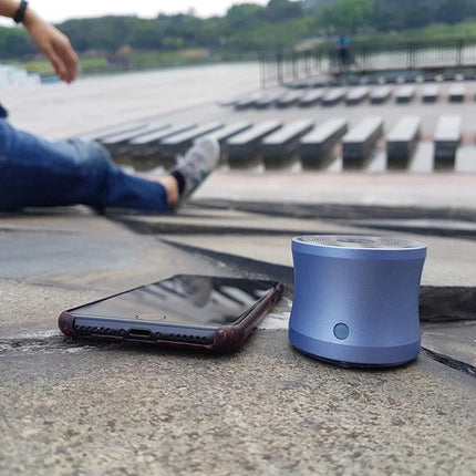 EWA Compact Shower Speaker For Portable Daily Hands Free Use portable blue speaker by phone on waterfront steps, splash-resistant