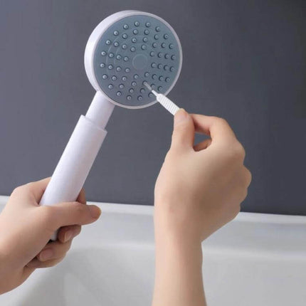 Shower Hole Cleaning Brush 10 Pack For Faucets And Drains - hand using slim nylon brush to clean shower head nozzle and faucet holes