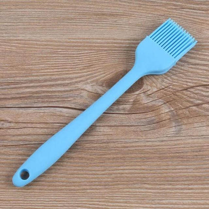 Silicone BBQ Oil Brush For Easy Basting Of Grilled Foods blue silicone basting brush on wooden background