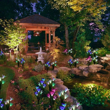 Simulated Lily 4-Head Solar Outdoor LED Lawn Lamp Decorative lighting a garden pathway and pond at night with multicolored lily-style heads
