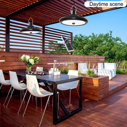 Smart Induction Solar Light For Indoor Outdoor Use With PIR Sensor hanging over modern patio dining area with solar panel in daytime