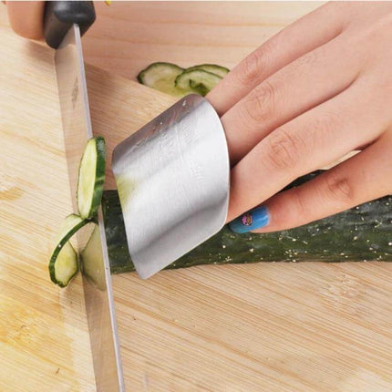 Stainless Steel Finger Guard For Safe Vegetable Cutting protecting finger while slicing cucumber on cutting board