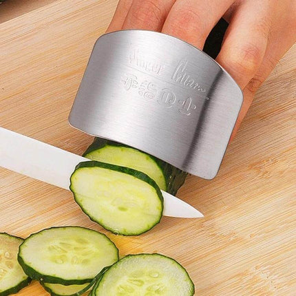 Stainless Steel Finger Guard For Safe Vegetable Cutting — stainless guard protecting fingers while slicing cucumber on wooden board