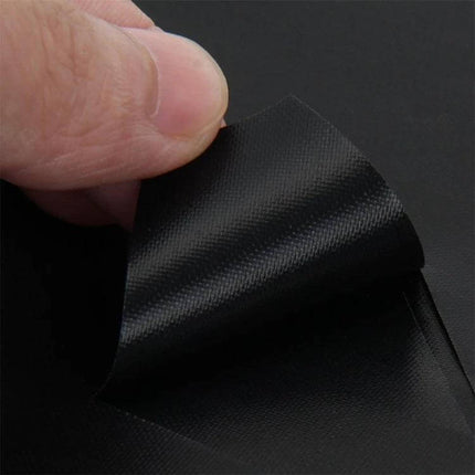 Stovetop Protective Cleaning Pad 27x27 cm for Daily Cooking - black reusable heat-resistant fiber pad being peeled by hand to show texture
