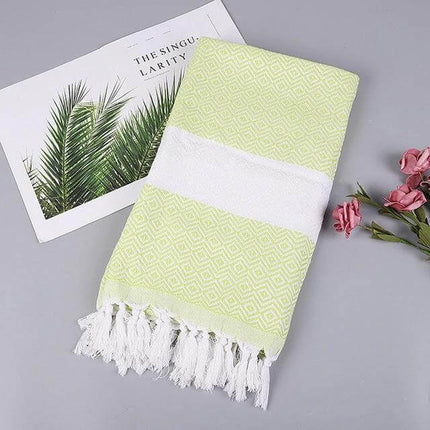 Striped Cotton Bath Towel With Tassels For Everyday Use folded pale green striped cotton-linen towel with white band and tassels on grey background