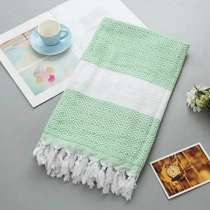 Striped Cotton Bath Towel With Tassels For Everyday Use folded mint-green diamond pattern towel with white stripe and tassels on tabletop