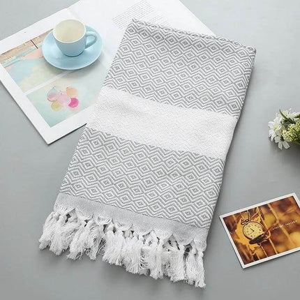 Striped Cotton Bath Towel With Tassels For Everyday Use — grey patterned cotton-linen towel 100x180cm with tassels shown folded on table
