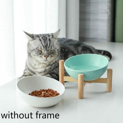 Essential Ceramic Pet Food Bowl for Home Mealtime on a wooden stand with tilted ceramic bowl beside cat, durable home feeding solution