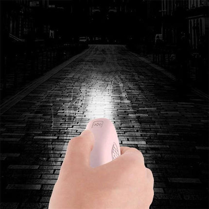 Rechargeable Personal Safety Alarm with Flashlight for Daily Protection held in hand shining light on dark street