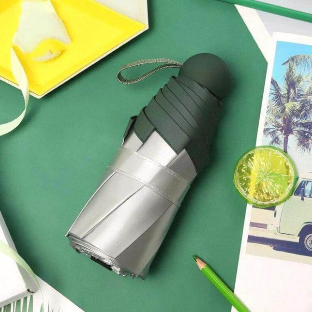 Compact Mini Pocket Umbrella for Everyday Sun and Rain Protection - Folded lightweight 260g umbrella in green and silver for commuters