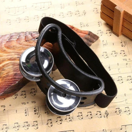 Aluminum Foot Bell for Home Music Practice Sessions attached to adjustable ankle strap on sheet music background
