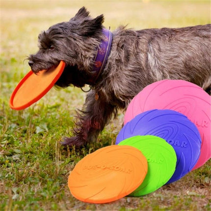 Rubber Flying Disc for Outdoor Dog Play and Training - small dog retrieving orange rubber flying disc in park with colorful discs on grass