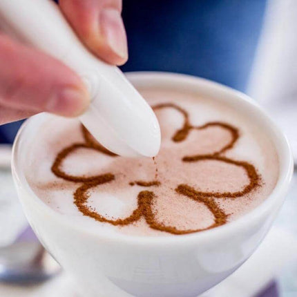 Electric Latte Art Pen for Coffee and Cake Decorating creating flower design on cappuccino foam with white handheld pen