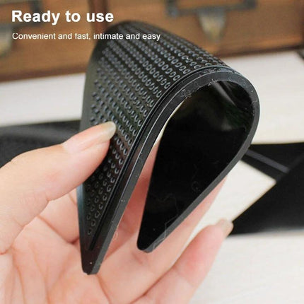 Non-Slip Stickers for Safer Bathroom Floors at Home — close-up of black textured adhesive strip held between fingers to secure bath mats