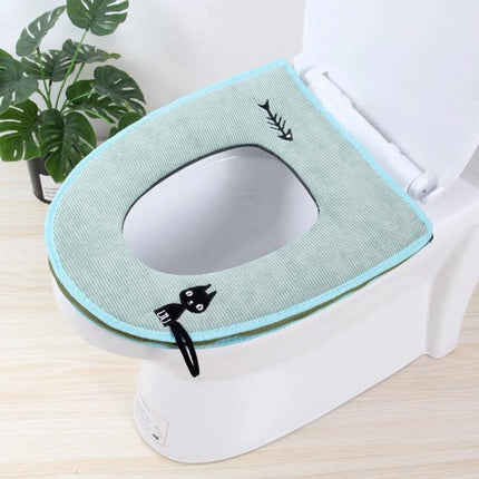 Cozy Washable Toilet Seat Cover for Cold Days on toilet in light blue with cat and fishbone design, soft polyester-cotton blend, washable, slip-on