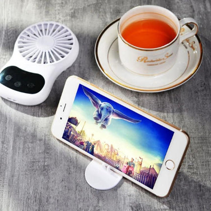 Compact Desktop USB Fan With Built-In Clock on a desk next to a smartphone stand and teacup, white fan in use for study or work