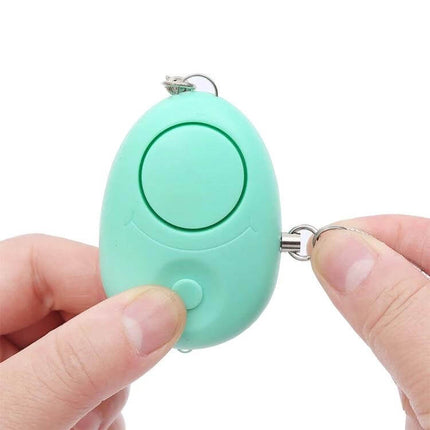 Portable Personal Safety Alarm with LED Light for Emergencies shown as compact mint keychain device held between hands