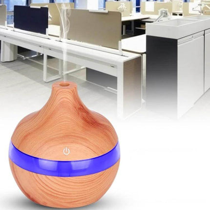 Wood Grain USB Waterdrop Aromatherapy Humidifier For Desk on office desk releasing mist with wood-grain finish and blue LED band