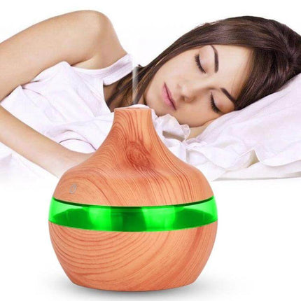 Wood Grain USB Waterdrop Aromatherapy Humidifier For Desk shown on bedside table emitting mist next to sleeping woman, wood-grain finish, USB-powered, 300ml