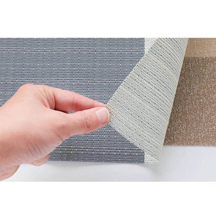 PVC Non Slip Table Mat 30x45cm Easy Clean Placemat shown being lifted to reveal non slip backing and woven neutral texture